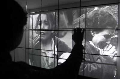 Un visitante ante uno de los vídeos de la muestra  Después de la alambrada , en Córdoba.