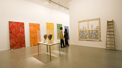 Dos hombres miran en La Casa Encendida el espacio reservado para la obra que Ryan McGinness y sus ayudantes colgarán al final de la exposición.rnRyan McGinness, en primer plano, con sus ayudantes en el taller de la Casa Encendida.