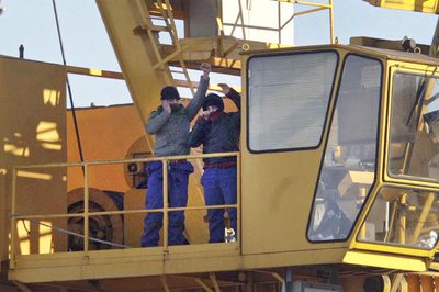 Dos parados del naval se suben a una grúa para pedir trabajo