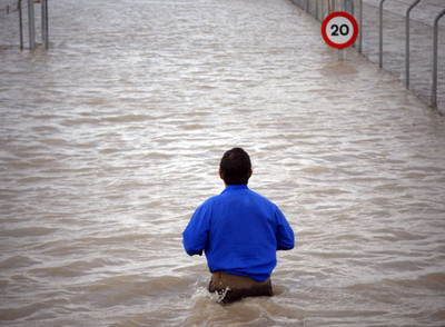 Un vecino de Las Pachecas intentaba ayer acceder a su domicilio tras la crecida del río Guadalete, en Jerez.