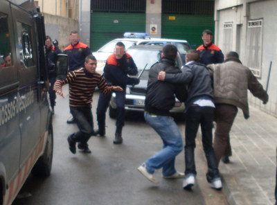 Un agente de los Mossos d'Esquadra carga contra un grupo de jóvenes.