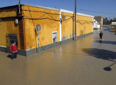 Dos hombres observan los daños producidos por el agua en la barriada jerezana de Lomopardo, una de las más afectadas por el temporal.rnVista de una de las carreteras comarcales cortadas ayer.