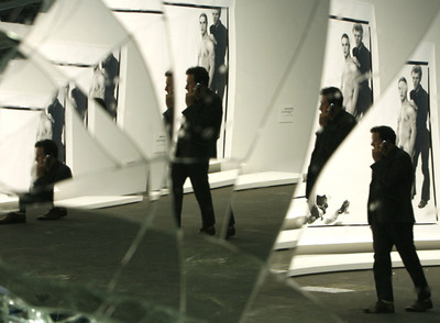 Un visitante se refleja en la obra  Mirror Wall , de Banks Violette, mientras pasa ante fotografías de Richard Avedon en la feria Art Basel de 2008.