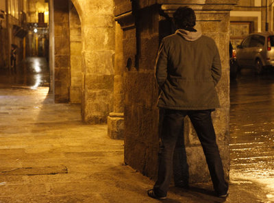 Un joven orina en una calle de la zona monumental de Santiago.