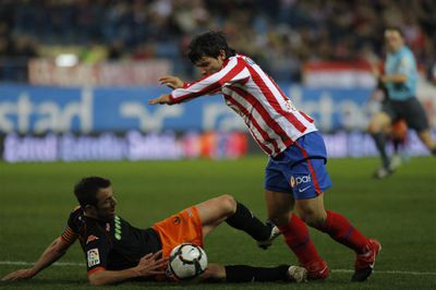 Marchena, ante Agüero, toca el balón con una mano en el área. Un penalti que Pérez Burrull (al fondo) no pitó de entrada, lo que provocó la protesta masiva del Atlético.