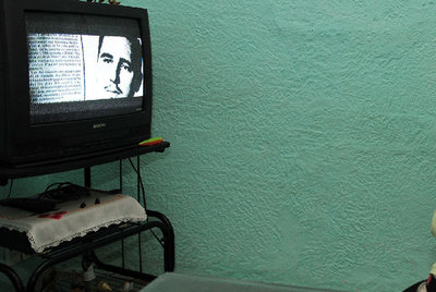 Una mujer sigue por televisión la serie  El que debe vivir , en La Habana.