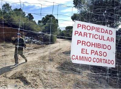 Un trabajador de Antonio Quesada, presunto asesino de Fernando Jurado, enseña la valla que divide los terrenos de ambos, motivo de disputa.
