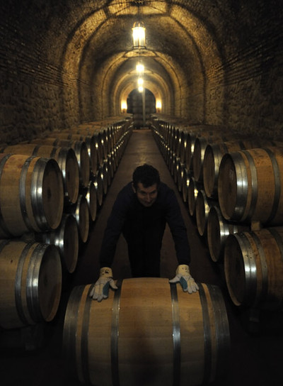 Un empleado coloca barricas de vino, en una bodega de Cenicero, en La Rioja.