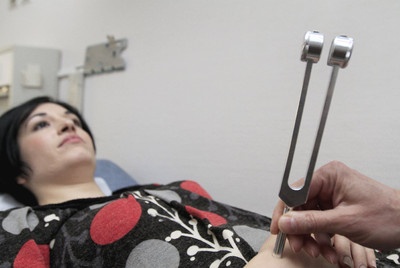 El médico Juan Pareja simula dos momentos de una exploración en su consulta a pacientes con narcolepsia. En la imagen con Sara Breñas