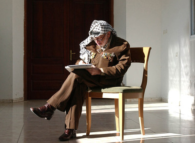 Yasir Arafat, presidente de la Autoridad Palestina, escribe unas notas en su oficina de Ramala, Cisjordania, el 26 de agosto de 2004.