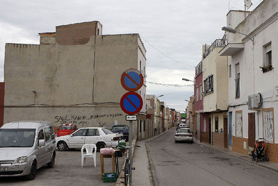 Una de las angostas calles del centro del barrio castellonense. A un lado, el solar sirve de aparcamiento.