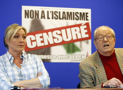 Marine Le Pen, junto a su padre, ante un cartel en el que se lee: 