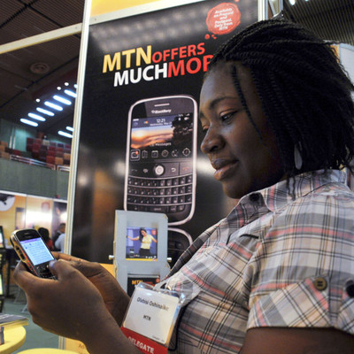 Una delegada prueba un teléfono móvil en la feria de las telecomunicaciones de Abuja (Nigeria).