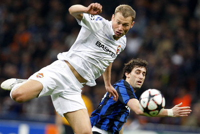 Vasili Berezutski salta junto a Diego Milito para tratar de que no pueda controlar el balón