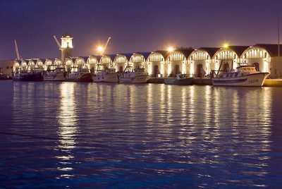 Una vista de los tinglados del puerto de Gandia al amanecer, una de las imágenes incluidas en la guía.
