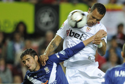 Luis Fabiano remata pese a la oposición de Ezequiel Luna.