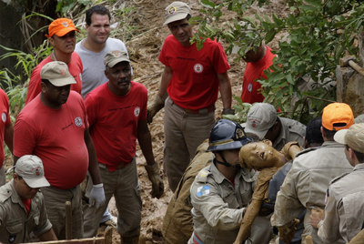 Los bomberos recuperan el cuerpo de un niño de ocho años, sepultado por el barro durante las inundaciones en una favela de Río de Janeiro.
