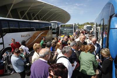 Autobuses fletados por las compañías aéreas recogen a viajeros afectados en el aeropuerto de Bilbao.