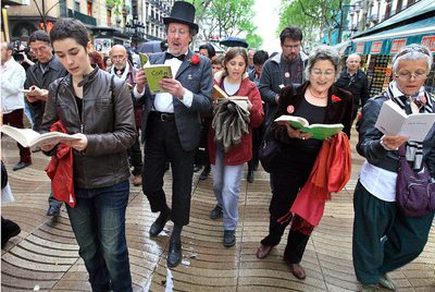 Participantes en el desfile del  Ramblaparaules  leyendo bajo la lluvia.