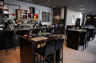 Comedor del restaurante Avant Garde, en Gijón. Abajo, ensalada de albaricoque con burrata.