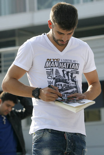 Piqué, firmando un autógrafo.