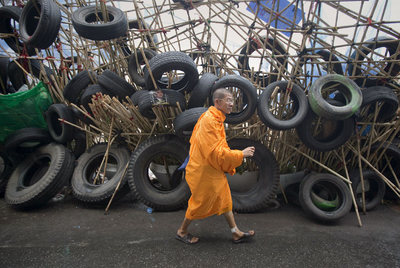 Un monje budista camina junto a las barricadas levantadas por los  camisas rojas  en el centro de Bangkok.