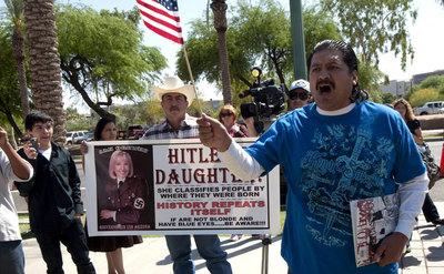 Manifestación de hispanos en Phoenix contra la gobernadora de Arizona, Jan Brewer, inspiradora de la ley antiinmigración. Brewer está representada en la foto con el uniforme nazi, y en la pancarta se alude a ella como 