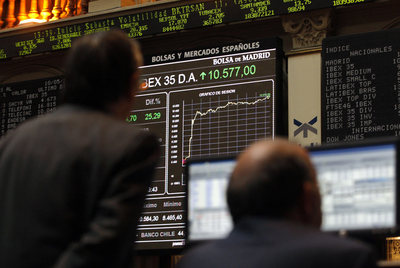 Un grupo de inversores observa el panel que muestra la subida del Ibex, ayer en la Bolsa de Madrid.