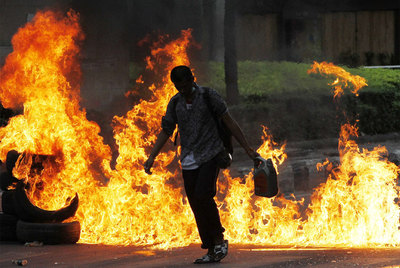 Un  camisa roja  quema neumáticos en una calle de Bangkok.