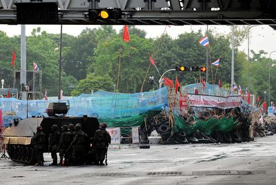 Soldados del Ejército tailandés, protegidos tras un carro blindado, avanzan hacia las posiciones de los 'camisas rojas'