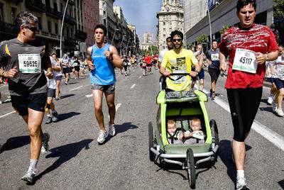 Participantes de la 32ª carrera de El Corte Inglés atravesando la calle de Pelai.