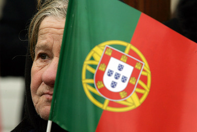 Seguidor del Primer Ministro Cavaco Silva lleva una bandera portuguesa en un acto de campaña