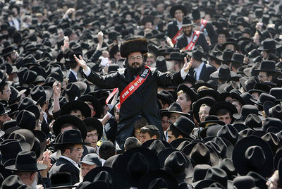 Manifestantes ultraortodoxos arropan a los padres condenados a penas de cárcel por desobedecer una decisión del Supremo. En sus bandas rojas, se lee: 