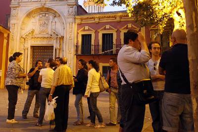Un grupo de personas ayer frente a la puerta cerrada de la basílica del Gran Poder en Sevilla.