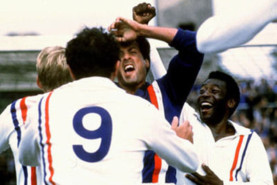 Sylvester Stallone, abrazado por sus compañeros (Pelé, a la derecha), tras parar el penalti en  Evasión o victoria. 