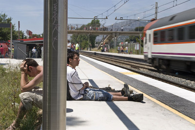 Unos jóvenes, sentados ayer en el anden de la estación de tren barcelonesa.