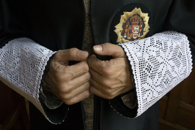 Las manos de un juez sobresalen de las puñetas de la toga.