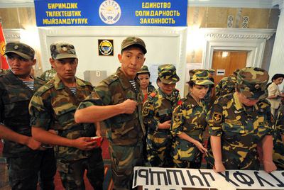 Soldados y policías kirguises aguardan para depositar su voto en un colegio electoral de Bishkek.