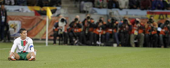 Cristiano Ronaldo, sentado en el césped, lamenta una jugada desperdiciada por su equipo durante el partido contra España