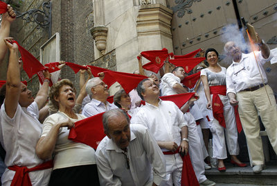 Varios asistentes celebran el chupinazo junto a la iglesia de San Fermín de los Navarros.