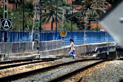 Una chica cruza las vías del tren el lunes a mediodía a su paso por el Camino de las Moreras, junto al barrio de Natzaret en Valencia. Ocurre continuamente.