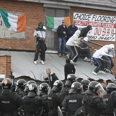 Policías y manifestantes durante los disturbios de ayer en Belfast.