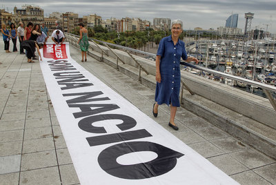 La presidenta de Òmnium, Muriel Casals, en primer término, en la terraza del Museo de Historia de Cataluña junto a la pancarta.