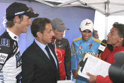 Sarkozy habla para la televisión en presencia de Schleck, Armstrong y Contador, al que el mandatario francés felicitó con un 