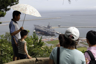 Un grupo de surcoreanos observa el portaaviones estadounidense  George Washington  en el puerto de Busan, al sur de Seúl.