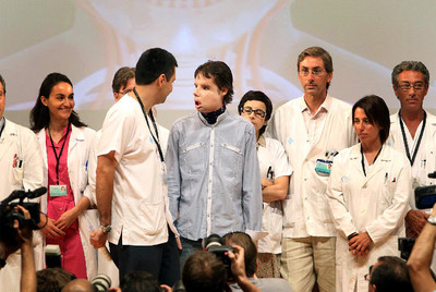 Óscar, el primer trasplantado completo de cara del mundo, junto al equipo médico del hospital Vall d'Hebrón, donde le operaron.
