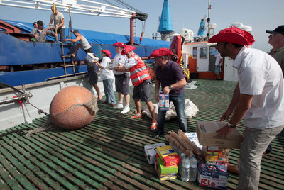 Trabajadores de Cruz Roja, Caritas y UGT suben alimentos al  Earsten Planet. 