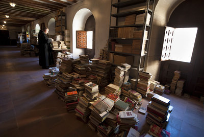 El hermano Roberto repasa un libro en la biblioteca del monasterio de Silos (Burgos).