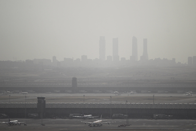 Contaminación por aire subsahariano con el aeropuerto de Barajas en primer término y al fondo las cuatro torres de la Castellana.