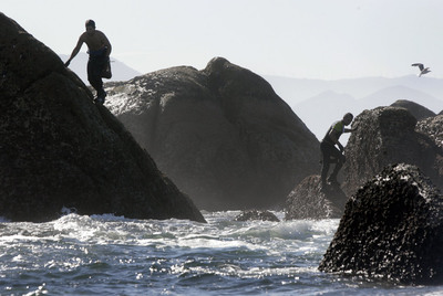Dos  percebeiros  mientras faenan en las rocas de Lira, en la Costa da Morte.